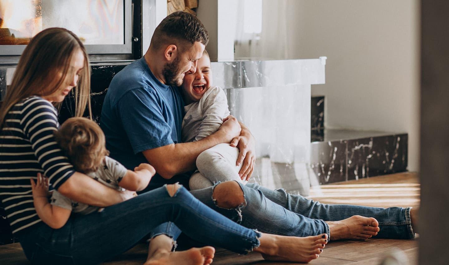 family sitting on the floor laughing